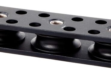 In alluminio anodizzato duro a spessore + PTFE con pulegge in delrin.